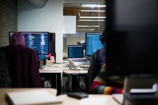 Business analysts in a computer lab analyzing call center ticket volume.