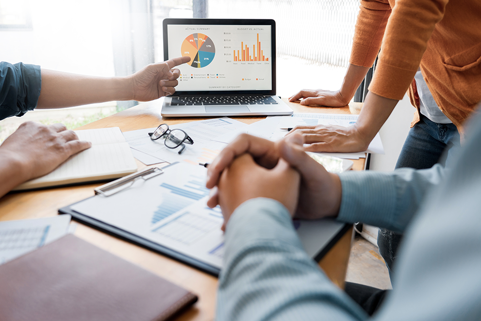 Une équipe marketing en réunion, discutant de l’analyse des données marketing à l’aide d’un graphique des solutions marketing de Minitab.